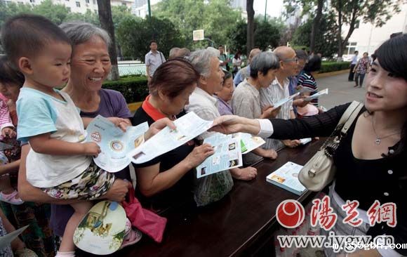 工作人员向市民发放环保知识读本。